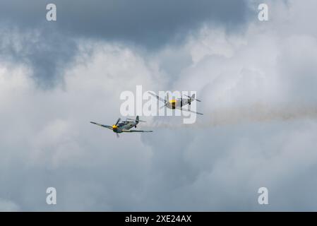 Hispano Buchon-Flugzeuge spielen die Rolle der deutschen Luftwaffe Bf-109 als Ziel für „Dogfight“, wobei ein hinterer Rauch nach dem Treffer ablief Stockfoto