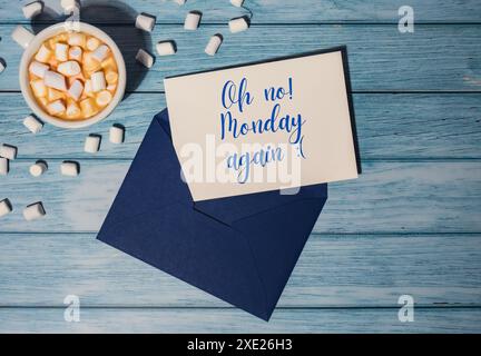 OH NEIN MONDAY AGAIN Konzepttext blauer Umschlag mit weißer Tasse Kaffee und Marshmallows auf hölzernem Hintergrund. Die meisten Depressin Stockfoto