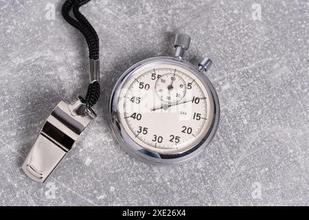 Vintage-Stoppuhr mit Pfeife auf grauem Hintergrund. Sportkonzept Stockfoto