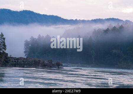 Ein breiter, voll fließender Gebirgsfluss mit einer schnellen Strömung. Stockfoto