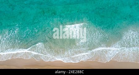 Ozeanwellen küssen das Sandstrand in einem ruhigen Strand Hintergrund. Stockfoto