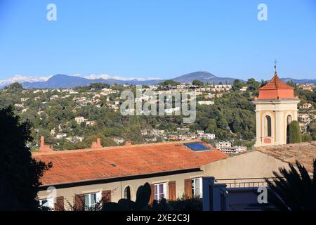 Kirche des Dorfes Cagnes sur Mer mit dem schneebedeckten Berg im Hinterland, Alpes Maritimes, französische Riviera Stockfoto