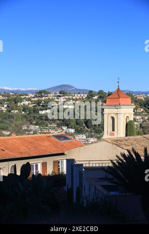 Kirche des Dorfes Cagnes sur Mer mit dem schneebedeckten Berg im Hinterland, Alpes Maritimes, französische Riviera Stockfoto