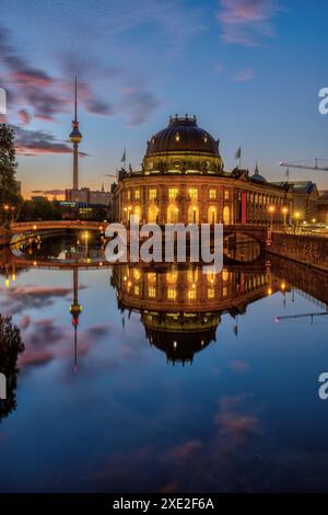 Das Bode-Museum und der Fernsehturm spiegeln sich bei Sonnenaufgang in der Spree in Berlin wider Stockfoto