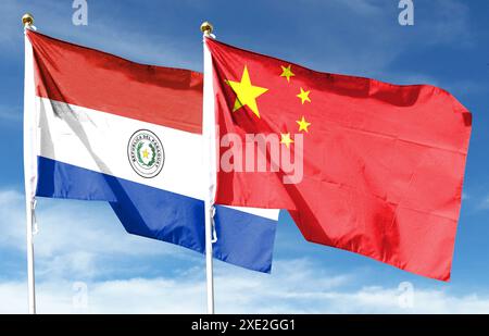 China-Flagge und Paraguay-Flagge am bewölkten Himmel. Im Himmel winken Stockfoto