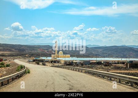 Straße zum Assal-See mit gelber Moschee und Bergen im Hintergrund, Region Arta, Dschibuti, Horn von Afrika Stockfoto