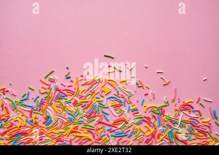Mehrfarbige Süßwaren, die auf einem rosafarbenen Stück krönt. Stockfoto