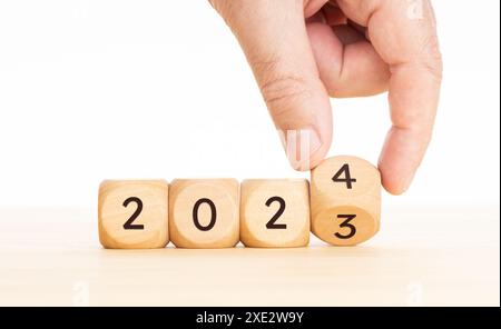 Neujahrskonzept. Händig klappt Holzblöcke von 2023 bis 2024 Jahren. Kopierbereich Stockfoto