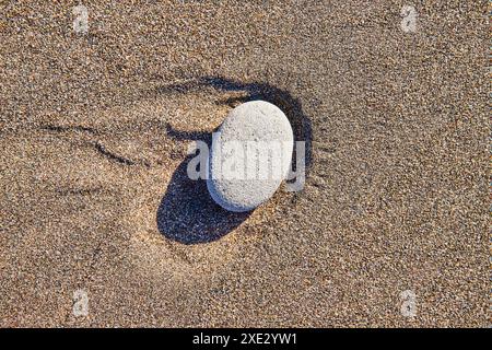 Grey Stone am Sandy Beach Nahaufnahme Stockfoto