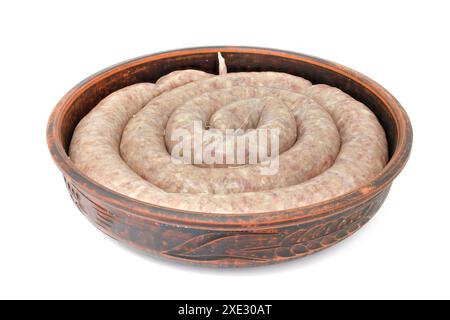 Hausgemachte Wurst zum Backen, roh in einer Tonschale isoliert auf weißem Hintergrund. Stockfoto