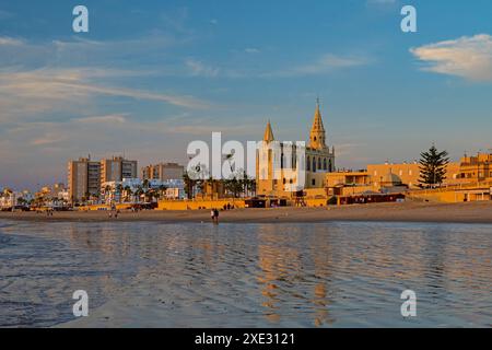Regla Strand mit Kirche und Leuchtturm in Chipiona im warmen Abendlicht Stockfoto