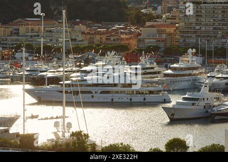 Monaco, Monte Carlo, 18. Oktober 2022: Sonnenuntergang Panorama von Port Hercule, vertäute Mega-Yacht, Sonnenspiegelung Stockfoto