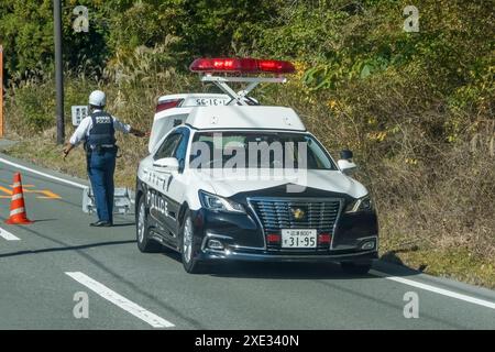 Yamanakako, Präfektur Yamanashi, Japan. November 2023. Ein Notfall-Polizeiauto und Offizier auf einem Hochstand Stockfoto