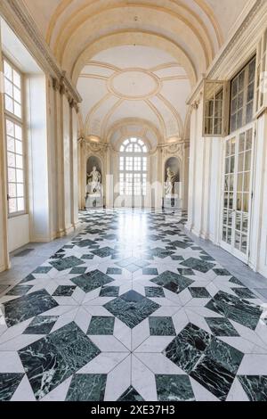 Venaria reale, Italien - Januar 2023: Luxuriöser Innenraum des alten Königspalastes. Galerieperspektive mit Fenster. Stockfoto