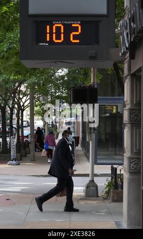 St. Louis, Usa. Juni 2024. An einem heißen Tag in St. Louis am Dienstag, den 25. Juni 2024, laufen die Menschen an der Zeit- und Temperaturuhr der Busey Bank vorbei. Foto: Bill Greenblatt/UPI Credit: UPI/Alamy Live News Stockfoto