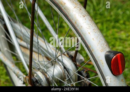 Nahaufnahme eines Hinterrads eines rostigen, schäbigen Oldtimer-Fahrrads. Stockfoto
