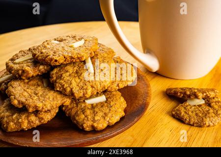 Haufen knuspriger, köstlicher, hausgemachter Kokosplätzchen auf Holzteller. Stockfoto