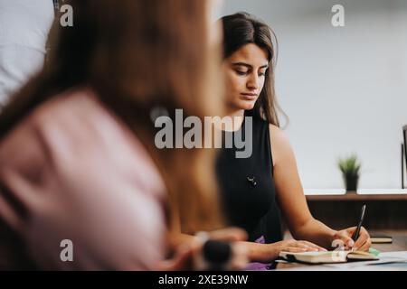 Fokussierte Geschäftsfrauen arbeiten in einer modernen Büroumgebung zusammen Stockfoto