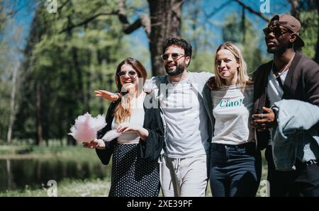 Eine Gruppe von Freunden, die einen sonnigen Tag gemeinsam im Park genießen und Lachen und Snacks teilen Stockfoto