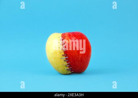 Zwei halbierte Äpfel (Oma smith und braeburn), rot und grün, zusammen mit Zink und Kupfer geheftet Stockfoto