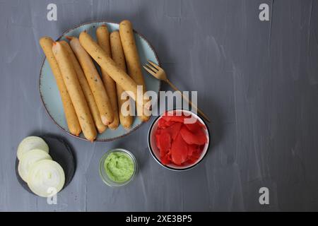 Würstchen mit roter weißer Sauce. Konzept des Mittagessens mit Würstchen und Snacks auf grauem Hintergrund mit Platz für Copyspace-Text im oberen Winkel. Stockfoto