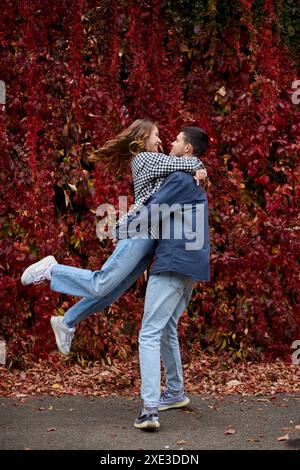 Junge Süße Frau Umarmt Freund. Im Herbst Draußen. Liebhaber, die im Park spazieren gehen. Attraktives, Lustiges Paar. Lovestory im Wald. Mann A Stockfoto