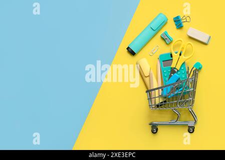 Draufsicht auf Warenkorb und Schulbedarf mit Platz für Text auf gelbem und blauem Hintergrund. Back-to-School-Konzept Stockfoto