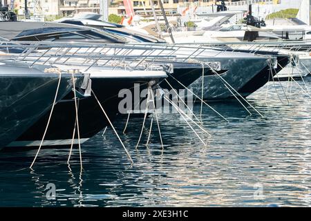 Sonnenstrahlen auf Hochglanzbooten, azurblaues Wasser, Ruhe im Hafen Herkules, Bögen von vertäuten Booten an sonnigen Tagen, Megayachten, Mona Stockfoto