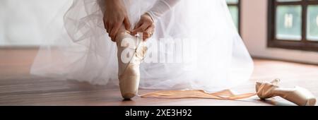 Ballerina in Ballettschuhen. Asiatische girlÂ Bänder von Zehenschuhen. Balletttänzerin, die Ballettschuhe in Dance stu trägt Stockfoto