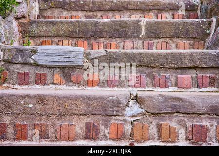 Verwitterte Ziegel- und Steintreppen aus der Perspektive der Niedrigperspektive Stockfoto