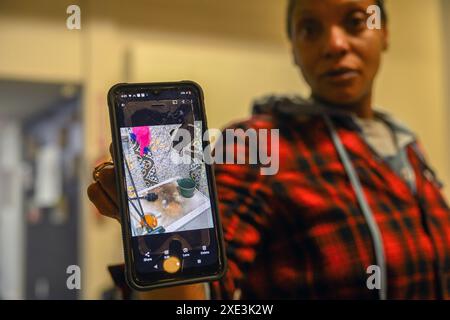 Sacramento, Kalifornien, USA. Februar 2024. TANIKA WILLIAMS hält ihr Handy mit einem Bild des schmutzigen Zustands der Dusche im Greens Hotel während einer Pressekonferenz in Sacramento hoch, wo sie mit ihrer Tochter Makaila, 2, auftrat. Ihre Familie wurde aus ihrem Zimmer im städtischen Obdachlosenheim gesperrt. (Kreditbild: © Rene C. Byer/ZUMA Press Wire) NUR REDAKTIONELLE VERWENDUNG! Nicht für kommerzielle ZWECKE! Stockfoto