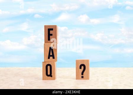 FAQ Holzblöcke und Fragen Mark ( ? ) Wort mit Holzwürfelblöcken am Strand in Wolkenlandschaft. FAQ( Stockfoto