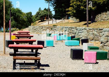 Mehrfarbige Stühle an der Küste mit Tischen und Bänken zum Entspannen. Stockfoto