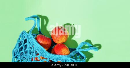 Wiederverwendbare Shopping String Tasche, offene Netztasche mit frischen Äpfeln. Blue Mesh Einkaufstasche mit Früchten Stockfoto