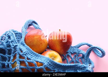 Wiederverwendbare Einkaufstasche, offene Netztasche mit frischen Äpfeln. Mesh-Einkaufstasche mit Früchten auf pi Stockfoto