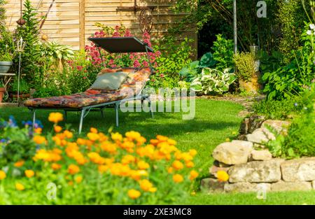 Entspannung im Landschaftsgarten. Gartenmöbel. Liege auf grünem Gras im Garten. Komfortabel Stockfoto