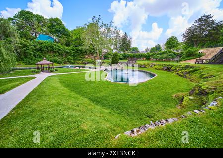 Ruhiger Garten mit Pool und Gartenlaube auf Augenhöhe Stockfoto