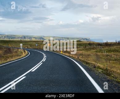 Blick auf die Autobahn und die Berge während der Autoreise in Island. Spektakuläre isländische Landschaft mit landschaftlich reizvoller Natur: Fjorde, Felder, Stockfoto