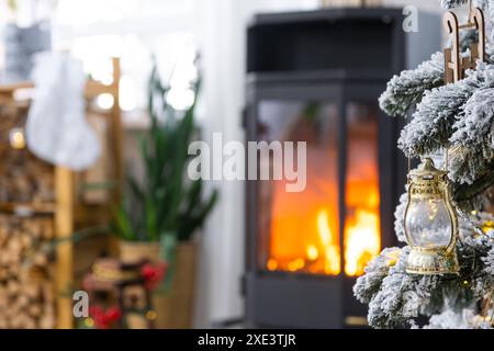 Schwarzer Metallofen, brennender Kamin im weißen festlichen Innenraum des Hauses ist für Weihnachten und Neujahr, Christm dekoriert Stockfoto