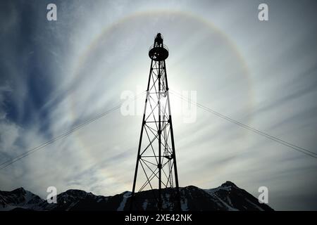 Ny Alesund. Juni 2024. Dieses Foto vom 21. Juni 2024 zeigt einen Halo um die Sonne in NY-Alesund, Svalbard, Norwegen. Als nördlichste dauerhafte Siedlung der Welt hat NY-Alesund vier Monate ununterbrochenen Tageslichts und vier Monate andauernde Dunkelheit jedes Jahr. Von Ende April bis Ende August geht die Sonne nie unter und verwöhnt Besucher mit dem Spektakel der „Mitternachtssonne“. Quelle: Zhao Dingzhe/Xinhua/Alamy Live News Stockfoto