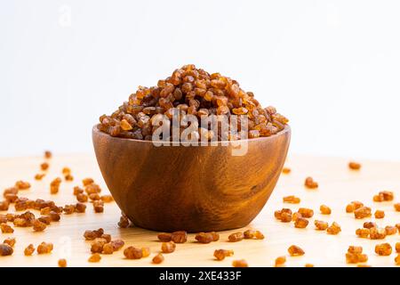 Blick auf Kristallkaramell, braune Zuckerwürfel in Holzschale. Stockfoto