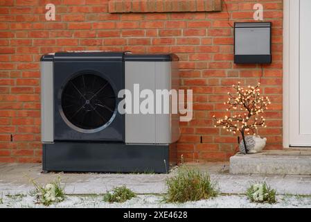 Luftwärmepumpe an der Außenfassade des Mehrfamilienwohnheims mit weihnachtslicht installiert. Stockfoto