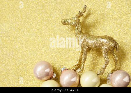 weihnachtszauber. Goldene Farbpalette des Weihnachtshirsches mit Dekor auf goldenem Hintergrund für Ihre Grußkarte. Draufsicht flach. Stockfoto