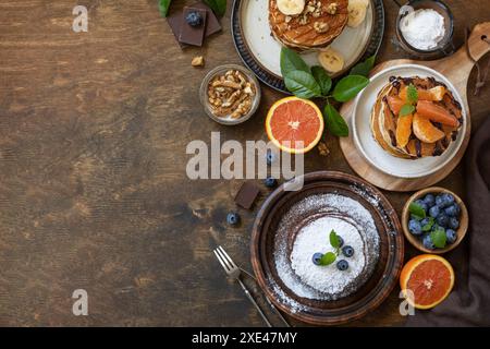 Pancake Day feiern, gesundes Frühstück. Köstliche hausgemachte amerikanische Bananenpfannkuchen mit Heidelbeeren, Nüssen, Karamell, Chocolo Stockfoto