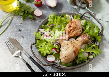 Gesunde saubere Ernährung. Fleisch mit frischem Salat. Gebackene Hähnchenkeulen und ein grüner veganer Salat aus grünen Blättern und Sp Stockfoto