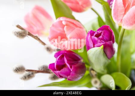 Bouquet von rosa und lila Tulpen mit bunten Wachteleiern. Konzept für Frühlings- und Osterferien. Stockfoto