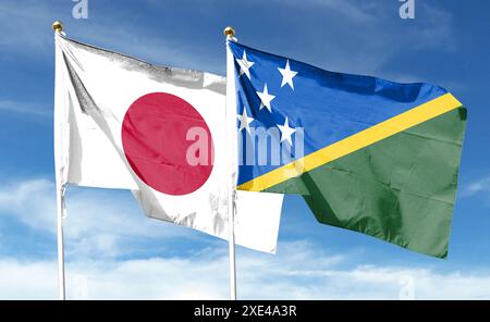 Japan-Flagge und Salomonen-Flagge am bewölkten Himmel. Im Himmel winken Stockfoto