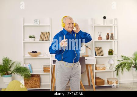 Glücklicher älterer Mann, der Musik über Smartphone und Kopfhörer genießt Stockfoto