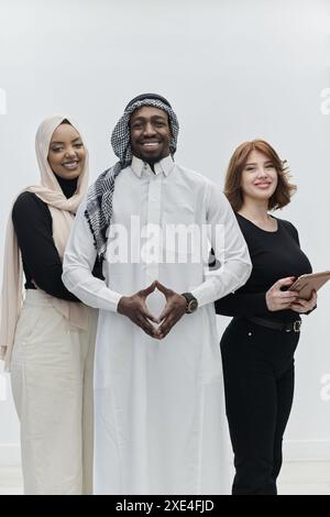 Ein arabischer Geschäftsmann steht selbstbewusst neben zwei Geschäftsfrauen und stellt ein kompetentes und vielfältiges Team dar, das Ehrgeiz verkörpert, Stockfoto
