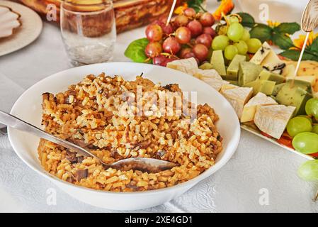 Nahaufnahme eines Löffels mit köstlichem Pilzrisotto in der Küche, das die cremige Textur und die herzhaften Zutaten hervorhebt. Stockfoto